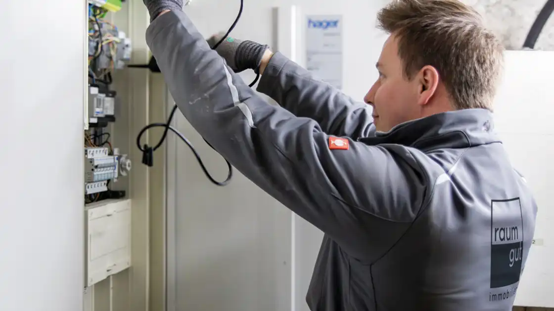 Ein Elektriker an einem Sicherungskasten