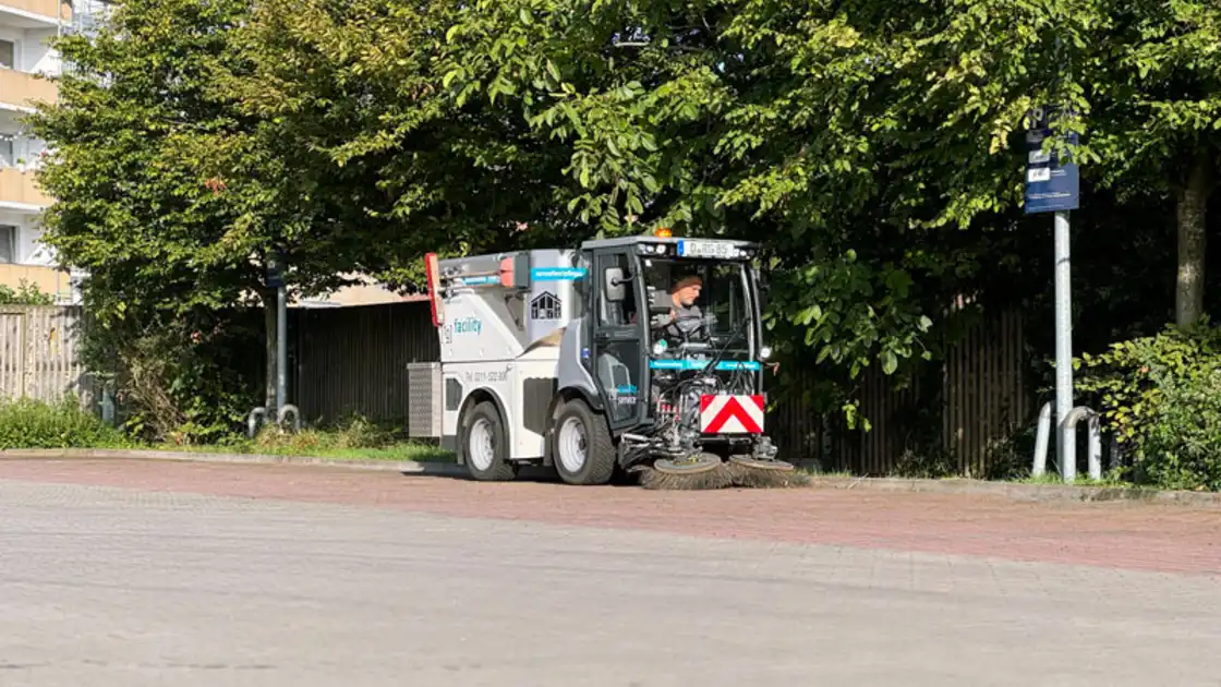 Eine raumgut Kehrmaschine fährt einen Weg entlang