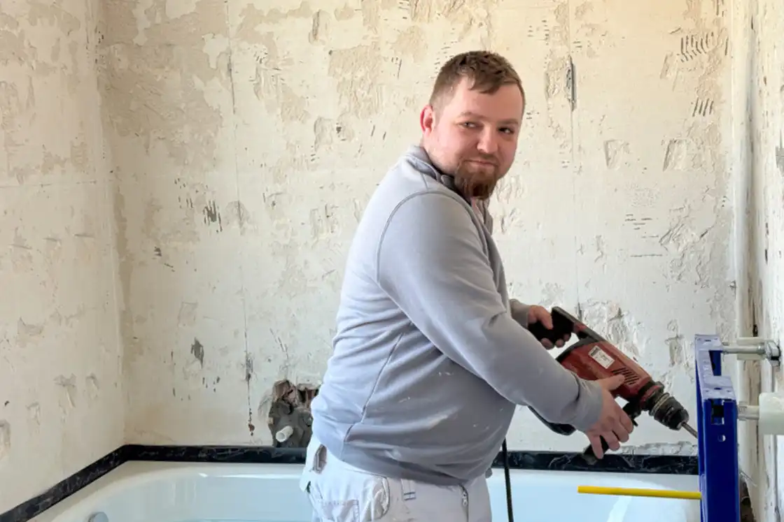 Ein Handwerker auf einer Badezimmer-Baustelle