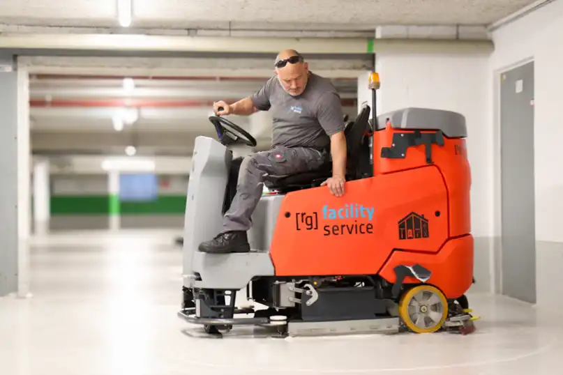 Ein Mitarbeiter von raumgut beim Reinigen mit einer Bodenreinigungsmaschine