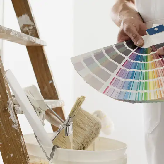 Ein Maler mit einer Farbpalette und Eimer und Pinsel