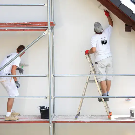 Zwei Maler von raumgut streichen eine Fassade