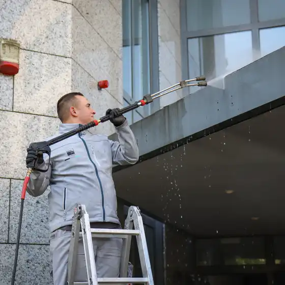 Ein Mitarbeiter reinigt eine Fläche mit einem Hochdruckreiniger