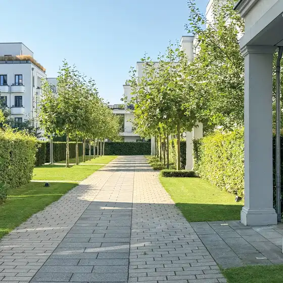 Ein Gehweg mit Grünflächen und Wohngebäuden