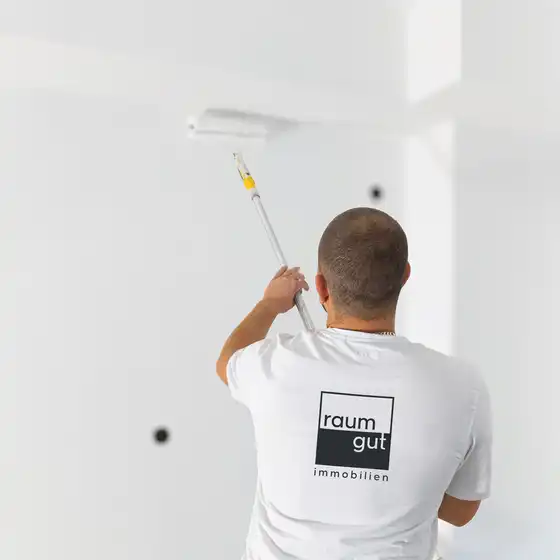 Ein Maler beim Streichen einer Wand