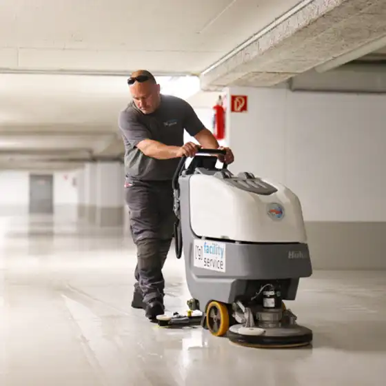 Ein Mitarbeiter von raumgut beim Reinigen mit einer Bodenreinigungsmaschine